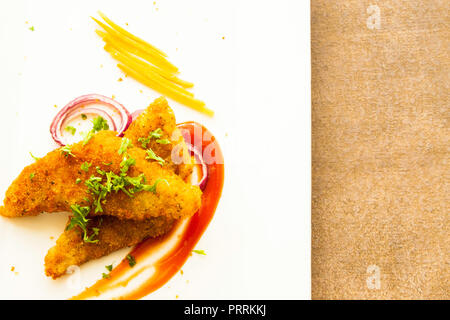 Fischfilet mit Brotkrumen gebraten und auf einem weißen Teller serviert Stockfoto