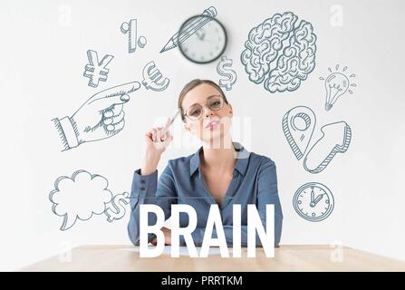 Nachdenklich geschäftsfrau am Tisch sitzen und halten Bleistift in der Hand, mit Business Icons und Gehirn Inschrift Stockfoto