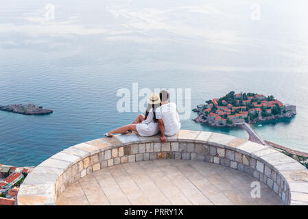 Paar umarmen auf Sicht und auf Insel Sveti Stefan in Budva, Montenegro suchen Stockfoto