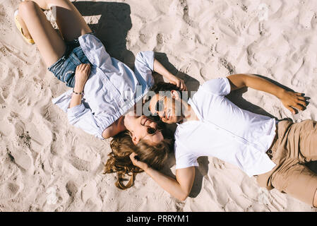 Draufsicht auf das glückliche Paar liegen auf sandigen Strand der Stadt Stockfoto