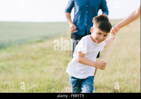 Zugeschnittenes Bild von Eltern und Sohn, die auf Feld Stockfoto