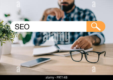 7/8 Schuß von Entwickler in Plaid Shirt mit SEO Search bar Stockfoto