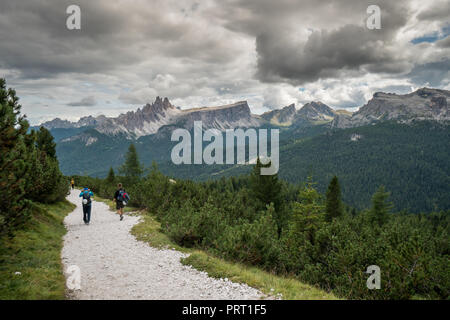 Bergsteiger zu Fuß die Straße runter in die Dolomiten Landschaft nach einem anstrengenden Aufstieg Stockfoto