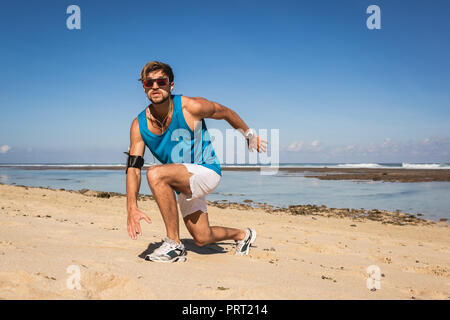 Athletischer Mann stürzt während Workout am Strand in der Nähe von Meer Stockfoto