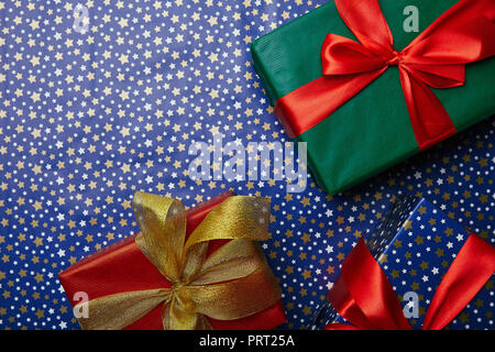 Flach mit eingepackte Geschenke mit Bändern auf Geschenkpapier mit Sternen Muster Stockfoto