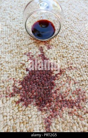 Glas Rotwein fiel auf dem Teppich, Wein auf dem Teppich verschüttet Stockfoto