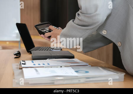 Finanzberater arbeiten mit dem Rechner im Büro. Buchhalter, Buchführung und die Berechnung der Einnahmen & Haushalt. Buchhalter Berechnung Finanzierung machen. Stockfoto