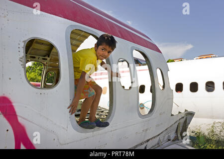 Junge Junge spielt in alten Platanen Wracks. Bangkok, Thailand Stockfoto