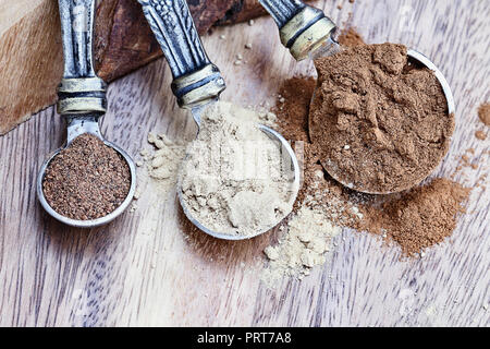 Messlöffel mit Pumpkin Pie spice Zutaten mit Zimt, Ingwer und Muskatnuss über einen rustikalen Holzmöbeln Hintergrund gefüllt. Extrem geringe Tiefe von f Stockfoto
