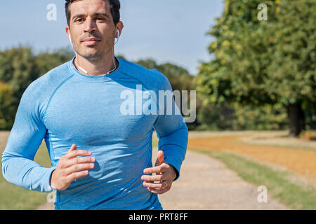 Attraktiver Mann Jogging im Park. Personal Trainer laufen und tun Übung Stockfoto