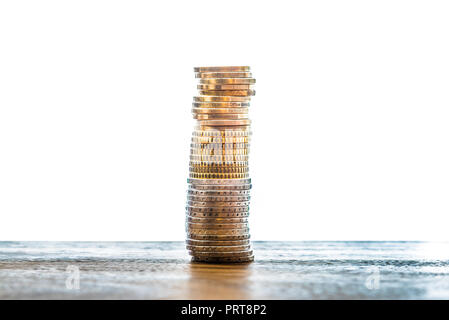 Stapel von Euro-münzen auf Tisch vor weißem Hintergrund Stockfoto