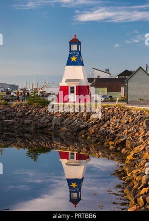 CHETICAMP, Nova Scotia, Kanada - Leuchtturm und Reflexion in Cheticamp Hafen, auf Cape Breton Island. Stockfoto