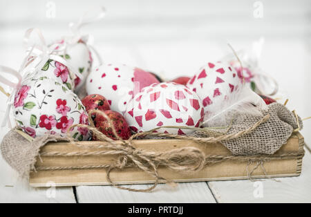Ostereier in Holzkiste auf einem hellen Hintergrund, das Konzept der Osterferien Stockfoto