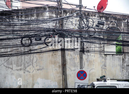 Störende Kabel der elektrischen Stange befestigt, das Chaos der Kabel und Leitungen auf einem elektrischen Pol in Bangkok, Thailand, Konzept der Elektrizität Stockfoto