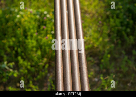 Wasser Metall Stahl rostige Rohre auf Wald Hintergrund voller Laub Gras und Büschen. selektive Fokus Makroaufnahme mit flachen DOF Stockfoto