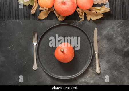 Thanksgiving oder Halloween Ort Einstellung mit orange Kürbis auf Schwarz. Ansicht von oben. Stockfoto