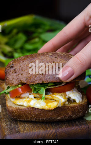 Sandwich mit dunklem Brot, Eier und Tomaten. Leckeres Frühstück. Stockfoto