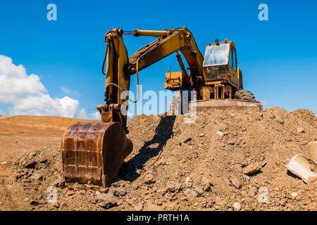 Bagger mit Schaufel am Boden Hill und blauer Himmel Stockfoto