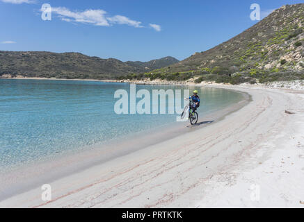 Radfahrer tun Wheelie am Strand, Villasimius, Sardinien, Italien Stockfoto