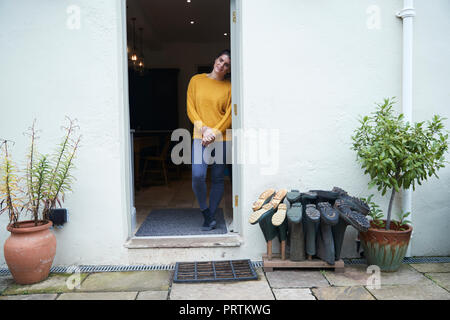 Frau in der Tür neben wellies Stockfoto