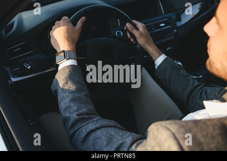 Blick von oben auf ein junger Geschäftsmann in Anzug mit seinem Auto fährt Stockfoto