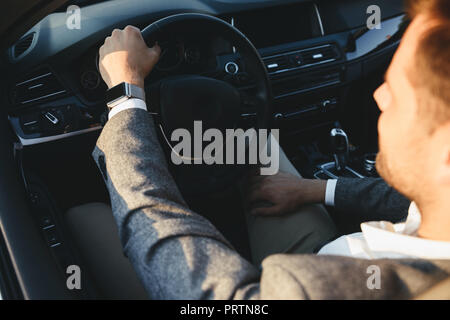Blick von oben auf ein Geschäftsmann in Anzug mit seinem Auto fährt Stockfoto