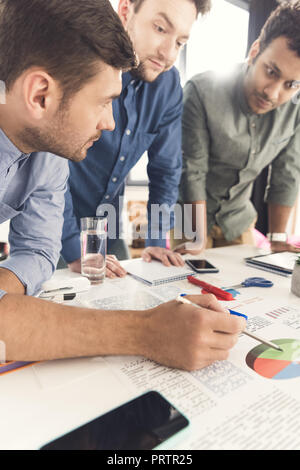 Drei Jungunternehmer am Tisch gelehnt und arbeiten am Projekt zusammen, Teamarbeit Geschäftskonzept Stockfoto