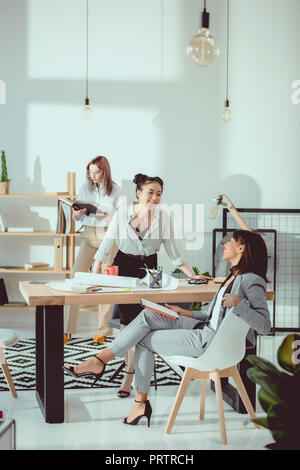 Jungen multiethnischen Geschäftsfrauen in formalen tragen gemeinsam im Büro Stockfoto