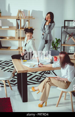 Jungen multiethnischen Geschäftsfrauen in formalen tragen gemeinsam im Büro Stockfoto