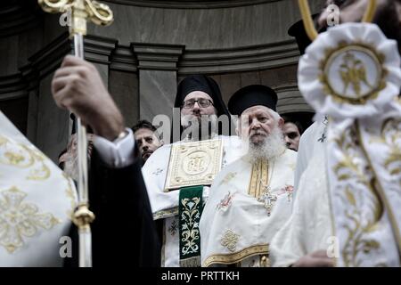 Orthodoxe Priester hält das Symbol des Heiligen an den Ausstieg aus der Kirche während der Litanei des hl. Dionysius Areopagita in Athen. Stockfoto