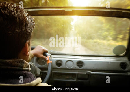 Eine Ansicht von hinter dem Lenkrad eines Autos. Der Blick von der Rückseite. Bewegung auf der Forststraße. Safari Auto SUV Stockfoto