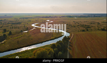 Herbst ländlichen Luftbild mit der Landwirtschaft Felder, Wiesen, Fluß, unbefestigte Straße und das Dorf im Hintergrund. Landschaft Feld nach der Ernte. Fluss Neman pa Stockfoto