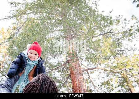 Baby Boy gehalten wird, die von Vater im Wald Stockfoto