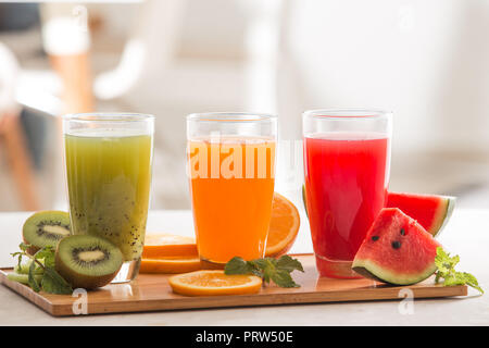 Frische Säfte Smoothie drei Glas Rot Grün Orange tropische Früchte Wassermelone, Kiwi, Orange. Selektiver Fokus Stockfoto