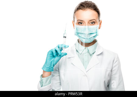 Ernst Ärztin in der medizinischen Maske holding Spritze isoliert auf weißem Stockfoto