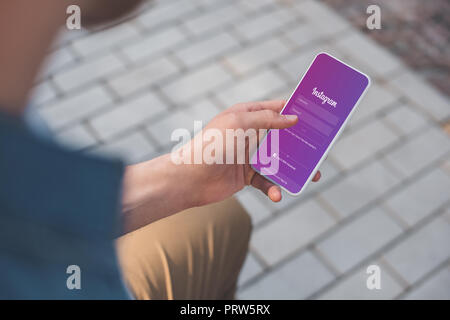 7/8-schuss mit Smartphone mit Instagram auf dem Bildschirm Mann Stockfoto