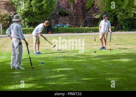 Männer spielen die nobble Partie Krocket auf dem Gelände des Bishops Palace in Wells Cathedral in Somerset England Großbritannien Stockfoto