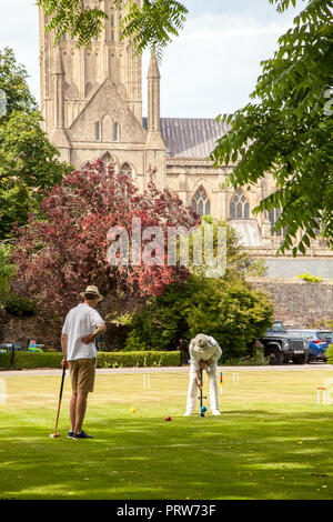 Männer spielen die nobble Partie Krocket auf dem Gelände des Bishops Palace in Wells Cathedral in Somerset England Großbritannien Stockfoto