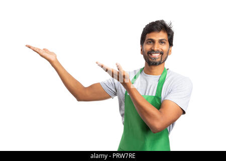 Lächelnd SB-Warenhaus oder Supermarkt männliche indische Mitarbeiter präsentieren leere Kopie text Bereich für Werbung auf den mit Palmen isoliert auf weißem Hinterg links Stockfoto