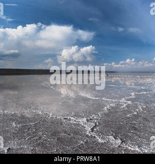 Weiße Kristalle auf dem toten Kochsalzlösung. Blauer Himmel mit weißen Wolken Stockfoto