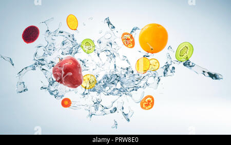 Wasser mit verschiedenen Früchten auf weißem Hintergrund, mixed Media. Stockfoto