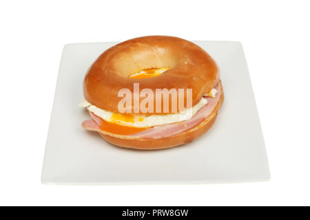 Schinken und Spiegelei Bagel auf einer Platte gegen Weiße isoliert Stockfoto