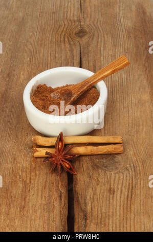 Chinesischen fünf Spice in einem ramekin mit Zimt und Sternanis auf alten verwittertes Holz Stockfoto