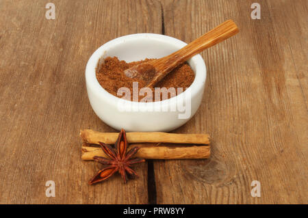 Chinesischen fünf Spice in einem ramekin mit Zimt und Sternanis auf alten verwittertes Holz Stockfoto