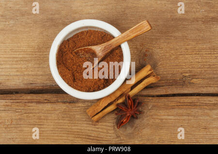 Chinesischen fünf Spice in einem ramekin mit Zimt und Sternanis auf verwittertes Holz Stockfoto