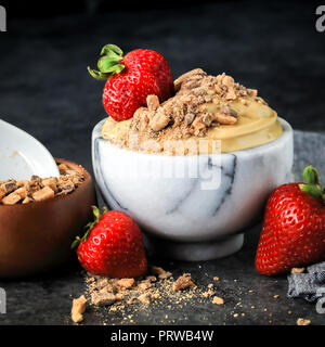 Cremige Schokolade English Toffee Frucht Dip mit 3 Zutaten - Frischkäse, mexikanische Vanille, brauner Zucker, in Bambus und Marmor Schüssel serviert. Stockfoto