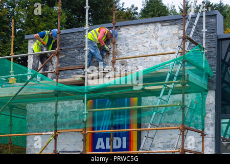 Erbauer auf Gerüsten oder Gerüst Mauerwerk entfernen von Aldi zu speichern. Stockfoto