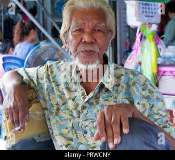 Portrait der männlichen Rikscha Fahrer, rauchen eine Zigarette, Bangkok, Thailand Stockfoto