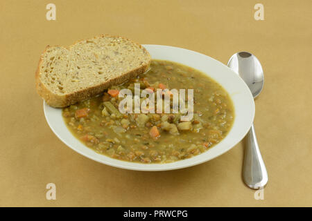 Linsen- Suppe mit Brot in Weiß Suppenteller mit Suppe Löffel Stockfoto