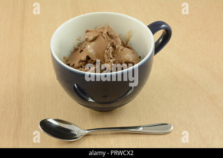 Schokoladeneis in Blau und Weiße Tasse mit Löffel Stockfoto